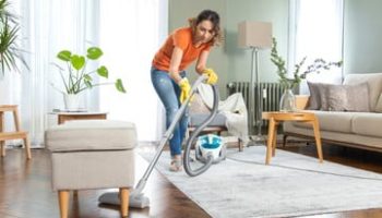 foto di una donna delle pulizie che aspira appartamento